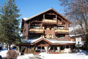 a large wooden building with snow in front of it at Hotel Le Samoyede in Morzine