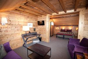 a living room with a bed in a log cabin at Hotel Le Samoyede in Morzine