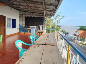 a long wooden table on a balcony with chairs at Silver Dolphin Guesthouse & Restaurant in Kratie