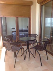 einen Tisch und Stühle auf einem Balkon mit einem Zimmer in der Unterkunft Sunnyview Park Ohrid apartments in Ohrid