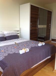 Un dormitorio con una cama grande con zapatos. en Sunnyview Park Ohrid apartments en Ohrid