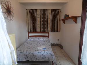 Habitación pequeña con cama y ventana en Casa da Jaca 02, en Itacaré