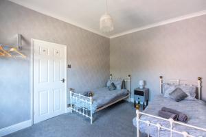 a bedroom with two beds and a door at The Old Nags Head in Bishop Auckland