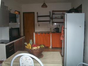una cocina con una cesta de fruta en una mesa con nevera en Casa da Jaca 02, en Itacaré