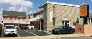 a parking lot with cars parked in front of a building at Franklin Terrace Motel in Seaside Heights +12 photos
