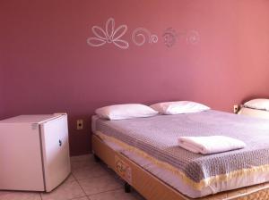 1 dormitorio con cama y pared púrpura en 50 Hotel, en Extrema