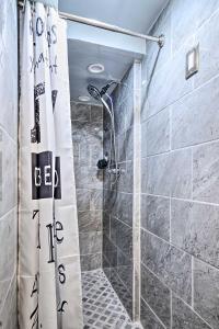 a shower with a shower curtain in a bathroom at Stylish DC Studio about 5 Mi to National Mall! in Washington