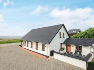 een wit huis met een zwart dak bij Holiday home Vestervig XXXIII in Vestervig