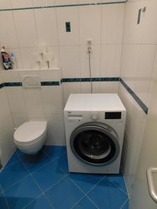 a bathroom with a washing machine and a toilet at CityApartment-Maribor in Maribor +21 photos