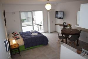 Un dormitorio con una cama y una mesa y una cocina. en Apart con Patio Exclusivo - Rosario Centro - Excelente - Cochera Opcional, en Rosario