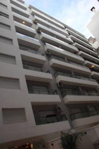 un gran edificio blanco con pájaros sentados en él en Apart con Patio Exclusivo - Rosario Centro - Excelente - Cochera Opcional, en Rosario