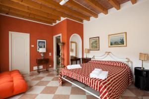 - une chambre avec un lit dans une pièce aux murs orange dans l'établissement Barchi Resort - Apartments & Suites, à San Felice del Benaco