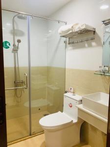 y baño con ducha, aseo y lavamanos. en GREEN PARK 2 HOTEL, en Quy Nhon