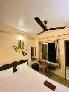 1 dormitorio con 1 cama con un pájaro en la pared en Mingo Guest House, en Pokhara