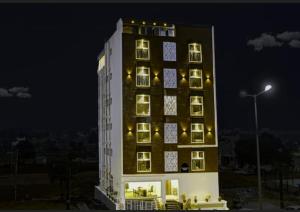 a tall building with lights on it at night at Fly Inn in Bangalore