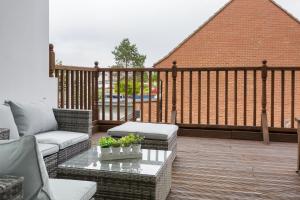 a patio with a couch and a table on a deck at Milton Heights - Modern 2 bedroom apartment with terrace in Portsmouth in Portsmouth