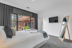a bedroom with a large bed and a television at Villa Simone - Tranquil Hideaway in the Heart of Echuca in Echuca