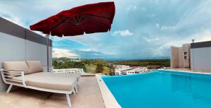 una silla y una sombrilla en un balcón con piscina en The Lanes Hotel en Tutong