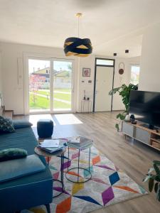 ein Wohnzimmer mit einem blauen Sofa und einem Teppich in der Unterkunft Casa moderna per vacanze rilassanti in San Martino in Fiume