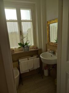a bathroom with a sink and a toilet and a window at AGRITURISMO CINQUE CAMINI in San Marzano Oliveto