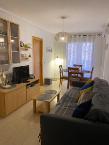 ein Wohnzimmer mit einem Sofa und einem TV in der Unterkunft Amazing 2-bedrooms apartment with pool Torrevieja center in Torrevieja