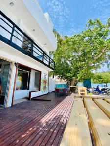 a house with a wooden deck with a tree at Hiraeth island home in Guraidhoo