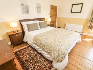 a bedroom with a large bed and two night stands at Tiplady Cottage in Leyburn