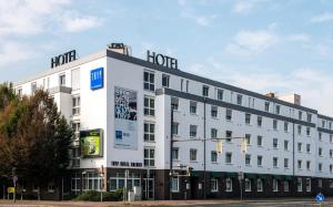 un gran edificio blanco con un cartel de hotel en Tryp by Wyndham Bremen Airport, en Bremen