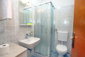 een badkamer met een douche, een wastafel en een toilet bij DINO Studio and Room Apartments in Portorož