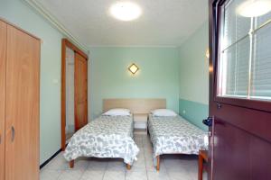 a bedroom with two beds and a window at DINO apartma studio in soba - DINO Apartment Studio and Room in Portorož
