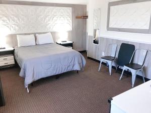 a hotel room with a bed and two chairs at Buoy 16 Motel by the Beach in Seaside Heights