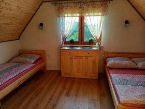 a small room with two beds and a window at Bieszczadzki Bohater Domki 533-502-137 in Polańczyk