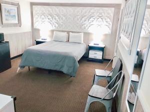 een slaapkamer met een bed en twee tafels en twee lampen bij Buoy 16 Motel by the Beach in Seaside Heights