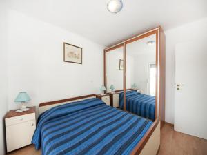 a bedroom with a blue bed and a mirror at Bertie's Lodge in Brna