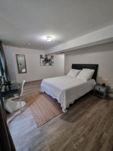 1 dormitorio con cama blanca y suelo de madera en Studio AVEC TERRASSE Carry le Rouet, en Carry-le-Rouet