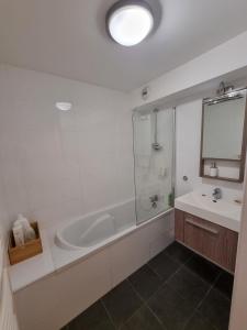 Baño blanco con bañera y lavamanos en Studio AVEC TERRASSE Carry le Rouet, en Carry-le-Rouet