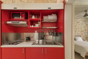 una cocina con armarios rojos y fregadero en Bungalow Episkopiko en Ioánina