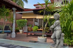 a statue of a little boy in front of a house at Ayubowan Guesthouse in Negombo