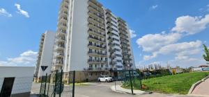un edificio de apartamentos alto con un coche estacionado al lado en Studio spațios,intim+ loc parcare propriu,vedere panoramică,utilat de lux, en Bucarest