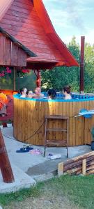 un grupo de personas sentadas en una bañera de hidromasaje en Cabana Gabriela, en Gârda de Sus