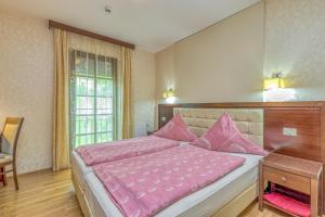 a bedroom with a large bed with pink sheets at Pool Villa Silva Marija Apartments in Pišece