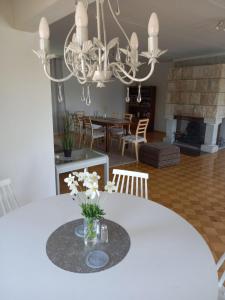 a dining room with a white table and a chandelier at Casper B&B in Haapsalu