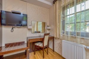 a room with a desk with a television and a chair at Pool Villa Silva Marija Apartments in Pišece