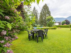 トレーポラッハにあるApartment in Tr polach Carinthia with poolの庭の芝生の上にテーブルと椅子