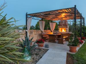 a patio with a fireplace and a wooden pergola at Picturesque Villa in Verteneglio with Pool in Brtonigla