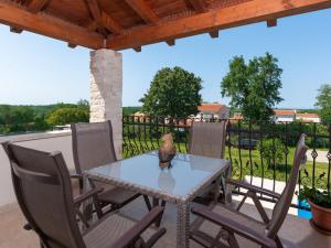 a table and chairs on a patio with a fence at Picturesque Villa in Verteneglio with Pool in Brtonigla