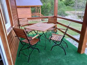 a wooden table and chairs on a porch at Cabane Areama Neagra in Izvoru Mureşului