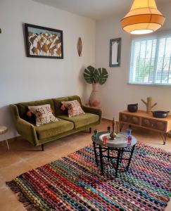 sala de estar con sofá verde y alfombra colorida en Bohemian 2 bed Apartamento Amarillo, en Agua Amarga