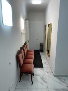 a waiting room with a row of chairs and a mirror at Riga Center Apartment in Old Town in Rīga