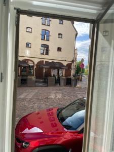 a red car parked in front of a building at Riga Center Apartment in Old Town in Rīga